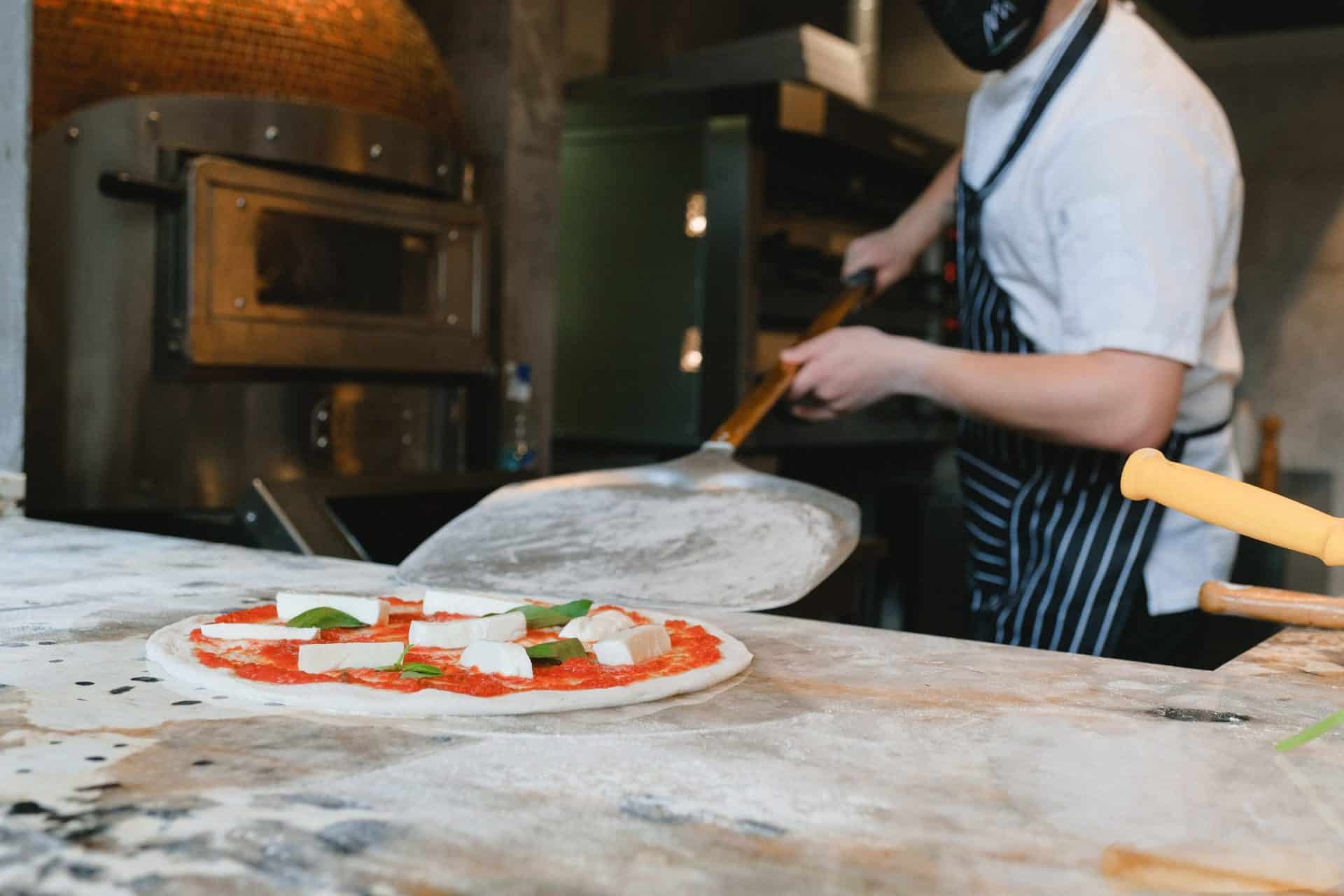 Putting a pizza into gas oven